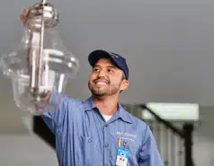 Professional electrician installing modern ceiling light fixtures during a home lighting upgrade.