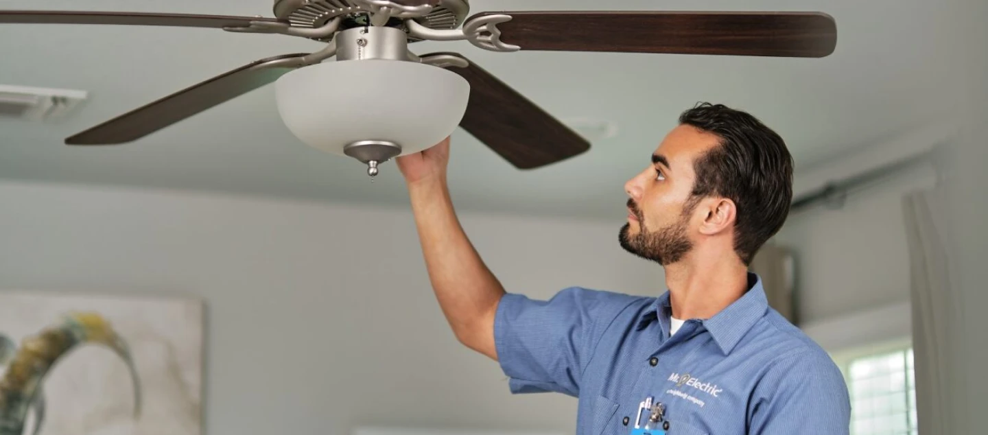 Mr. Electric electrician installing ceiling fan.