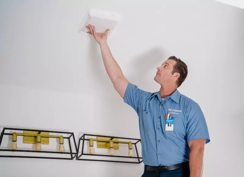 Mr. Electric electrician installing a carbon monoxide detector 