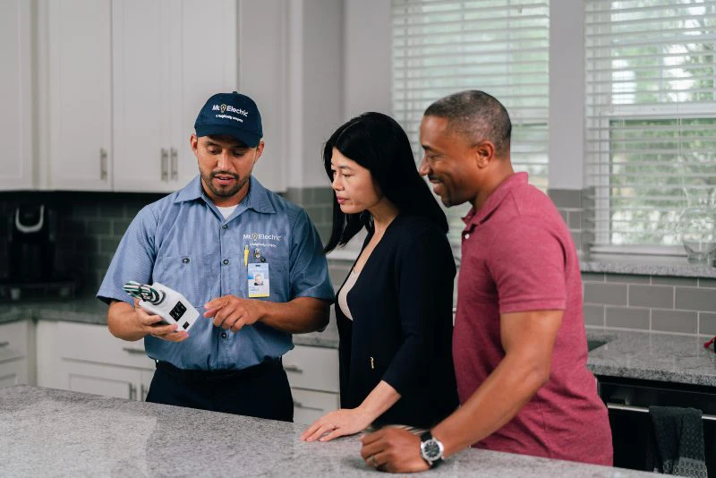 MRE electrician showing an electrical panel to customers.