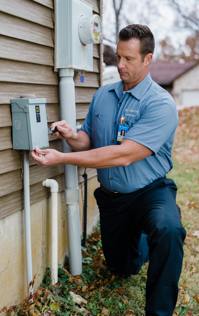 A MRE electrician setting outdoor outlet installation.