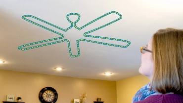 Fan icon on the ceiling while a person is staring at the ceiling wondering how to install a fan.